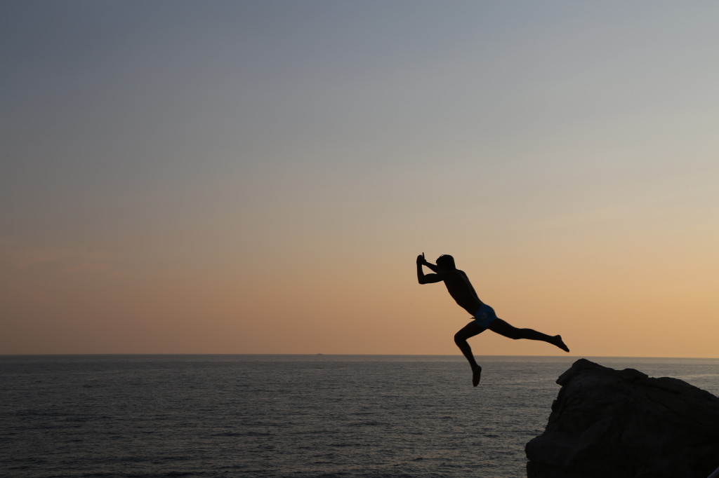 Rock divers jumping off the rocks in Dubrovnik's old city.